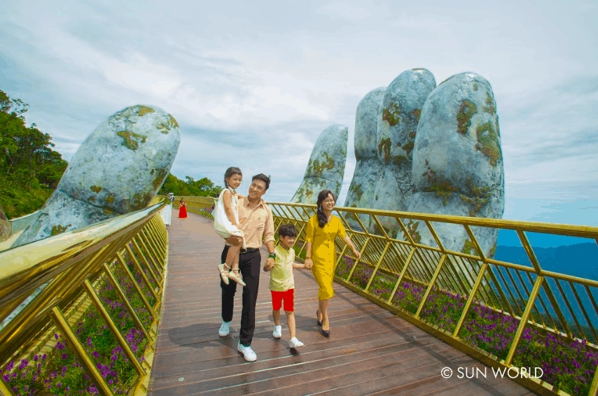 Cầu Vàng được làm từ thép tấm sơn nhũ vàng sáng bóng, 2 bên cầu là hoa cúc Nữ hoàng xanh Lobelia